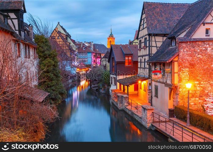 Christmas Little Venice in Colmar, Alsace, France. Traditional Alsatian half-timbered houses, church and river Lauch in Petite Venise or little Venice, old town of Colmar, decorated and illuminated at christmas time, Alsace, France