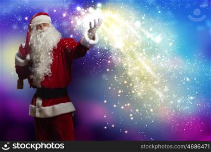 Christmas magic. Santa Claus with gift bag behind shoulders