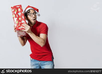 Christmas man holding and listening a gift box. Christmas guy holding and listening a gift box. Excited christmas people holding and listening a gift. Concept of guessing a christmas gift