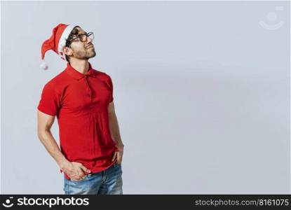 Christmas man with hand in pocket looking at copy space. Guy in Christmas hat with hands in his pocket looking at a promo, Christmas man with hands in his pocket looking at an advertisement