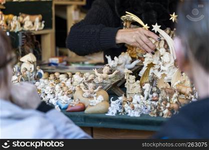 Christmas market booth with different wooden figures, a woman is putting one of the figures in position