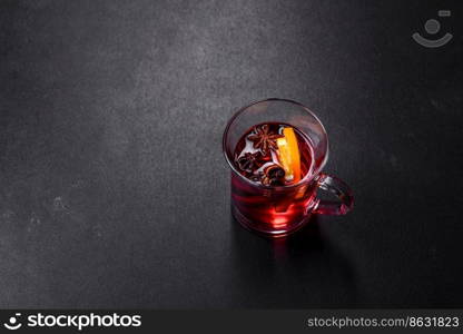 Christmas mulled red wine with spices and fruits on a concrete table. Traditional hot drink at Christmas time. Christmas mulled red wine with spices and fruits on a concrete table