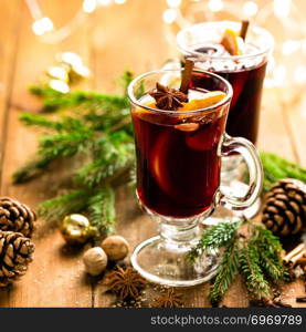 Christmas mulled red wine with spices and oranges on a wooden rustic table. Traditional hot drink at Christmas