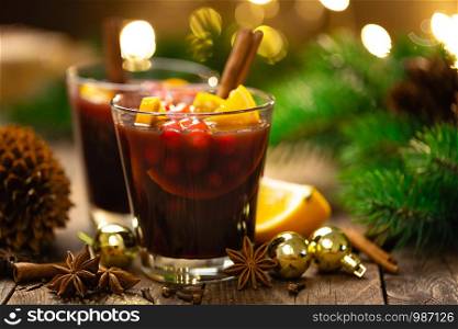 Christmas mulled red wine with spices, cranberry and oranges. Traditional hot drink or beverage, festive cocktail at Xmas or New Year with decorations