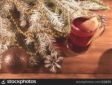 Christmas mulled wine with fir tree and decor on wooden table. Christmas mulled wine with lemon on wooden background. Vintage style