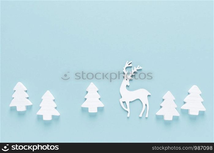 Christmas, New Year or Noel holiday farytail festive winter greeting card with decorations, deer and x-mas fir trees on blue background, flat lay composition, top view, space for text
