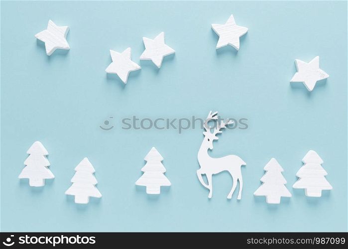 Christmas, New Year or Noel holiday farytail festive winter greeting card with decorations, deer, stars and x-mas fir trees on blue background, flat lay composition, top view, space for text