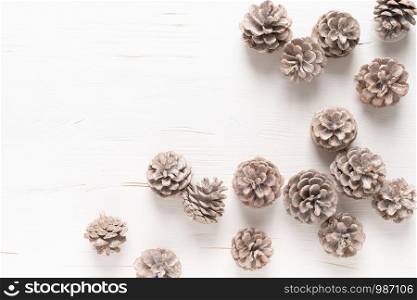 Christmas, New Year or Noel holiday festive winter greeting card with pine cones on white wooden background, xmas flat lay composition, top view, space for text