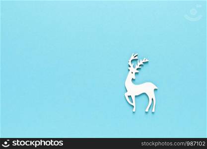 Christmas, New Year or Noel holiday festive winter greeting card with xmas decorations, deer on blue background, x-mas flat lay composition, top view, copy space