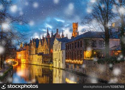 Christmas night cityscape with a medieval tower Belfort and the Green canal, Groenerei, in Bruges, Belgium. Belfort and Green canal in Bruges
