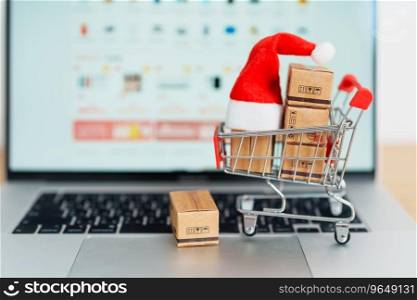 Christmas Online Shopping concept. Boxes with shopping cart on a laptop computer. Sale and discount during Christmas and New Year holiday, ecommerce, shipping delivery, logistics and Cyber Monday