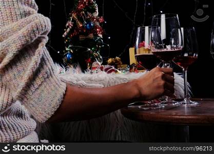 Christmas or New Year Celebration people hands with crystal glasses full of champagne near the Christmas tree and space for your text