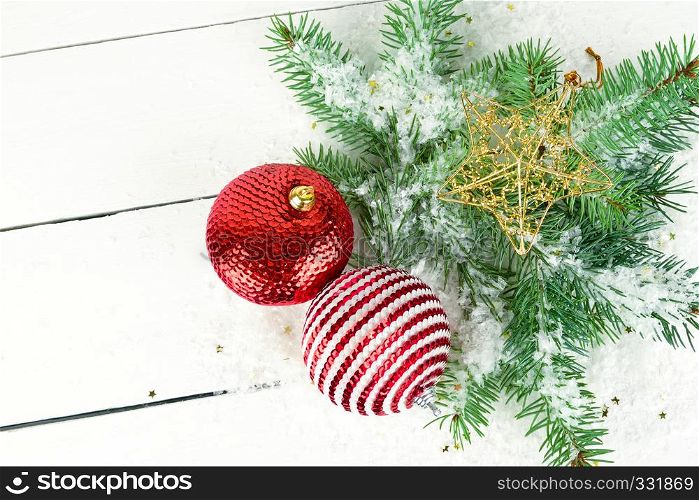 Christmas or New Year ornament. Sprigs of fir and bright decorations on a white wooden surface.