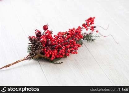 Christmas ornament. Branch of red berries on gray wooden background