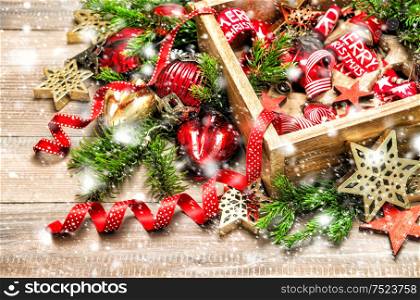 Christmas ornaments with christmas tree branches. Festive red and golden decoration with falling snow effect