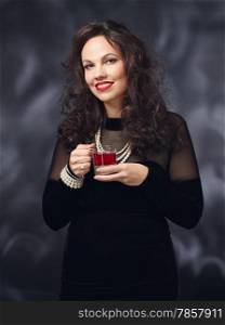 Christmas party, beautiful adult woman wearing black dress and she drinks mulled wine