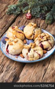 Christmas pastries with plum. Christmas sweet plum buns on the background of Christmas decorations