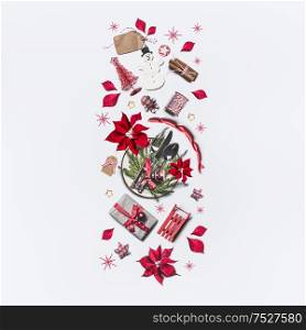 Christmas pattern composition with various holiday objects: poinsettia, gift box, festive table setting, Christmas tree, tags, snowflakes and ribbon on white background. Top view. Flat lay. Border