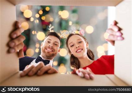 christmas, people and holidays concept - happy couple opening gift box over festive lights background. happy couple opening christmas gift box