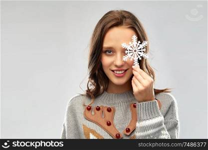 christmas, people and holidays concept - happy young woman with snowflake decoration wearing ugly sweater. woman in christmas sweater with reindeer pattern