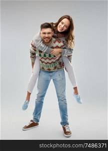 christmas, people and holidays concept - portrait of happy couple having fun at ugly sweater party. happy couple at christmas ugly sweater party