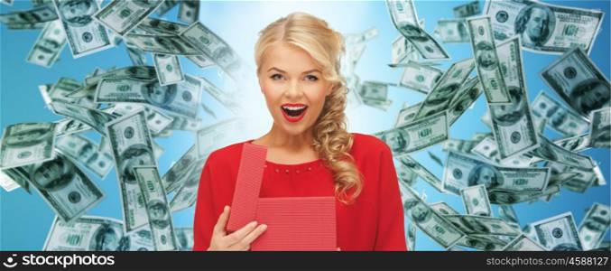 christmas, people, finance and holidays concept - smiling woman in red dress with many gift boxes over blue background and money rain