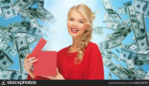 christmas, people, finance and holidays concept - smiling woman in red dress with many gift boxes over blue background and money rain