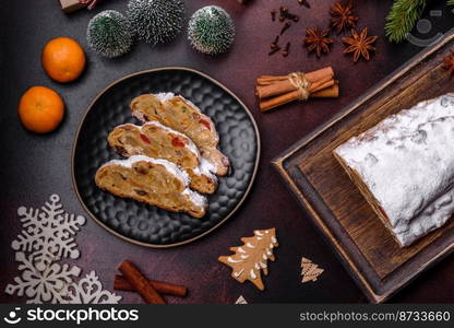 Christmas pie stollen with marzipan, berries and nuts on a dark concrete background. Preparation of the festive table. Christmas pie stollen with marzipan, berries and nuts on a dark concrete background