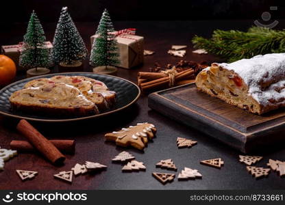 Christmas pie stollen with marzipan, berries and nuts on a dark concrete background. Preparation of the festive table. Christmas pie stollen with marzipan, berries and nuts on a dark concrete background