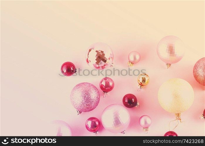 Christmas pink and golden decorations on pink background, toned. Christmas decorations on pink