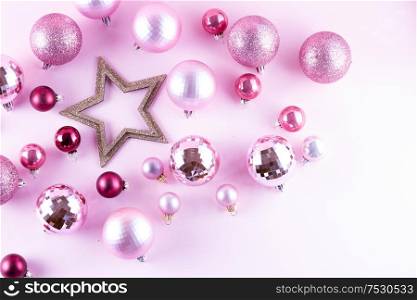 Christmas pink balls and star decorations on pink background. Christmas decorations on pink