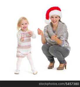 Christmas portrait of happy mother and baby girl dancing