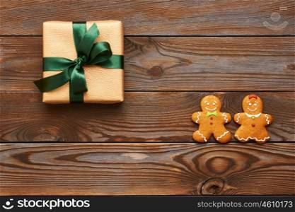 Christmas present and homemade gingerbread cookies on wooden background