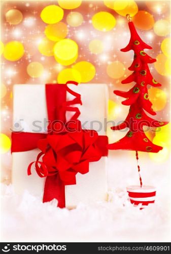 Christmas present, gift box with tree glowing bokeh lights background and winter ornament, home decoration for holidays at wintertime, new year eve