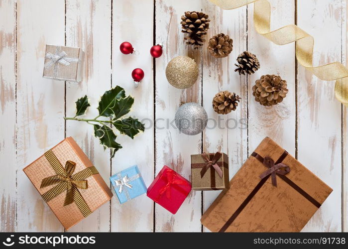 Christmas presents and decorations over a rustic wooden table seen from above. Christmas presents and decorations over a rustic wooden table