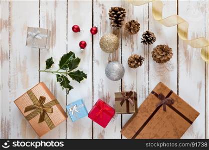 Christmas presents and decorations over a rustic wooden table seen from above. Christmas presents and decorations over a rustic wooden table