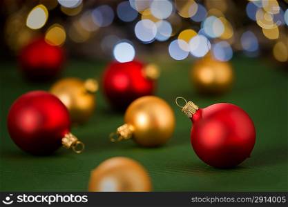 Christmas red and golden baubles on green color paper in the background