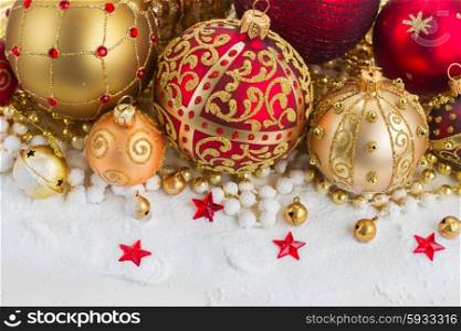 christmas red and golden heart with evegreen tree . pile of christmas red and golden ball in snow