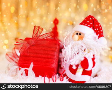 Christmas red gift box present as holiday abstract background card with Christmas tree Santa Claus ornament &amp; defocus lights decoration