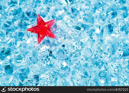 christmas red glass star on cold blue ice background