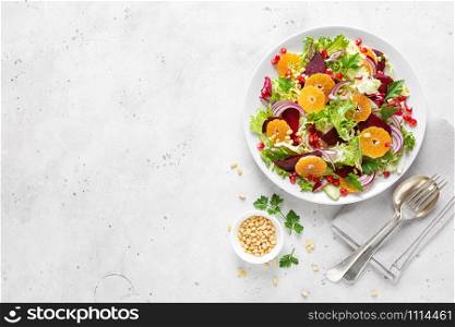 Christmas salad with boiled beet, red onion, tangerines, pomegranate, parsley, pine nuts and lettuce leaves