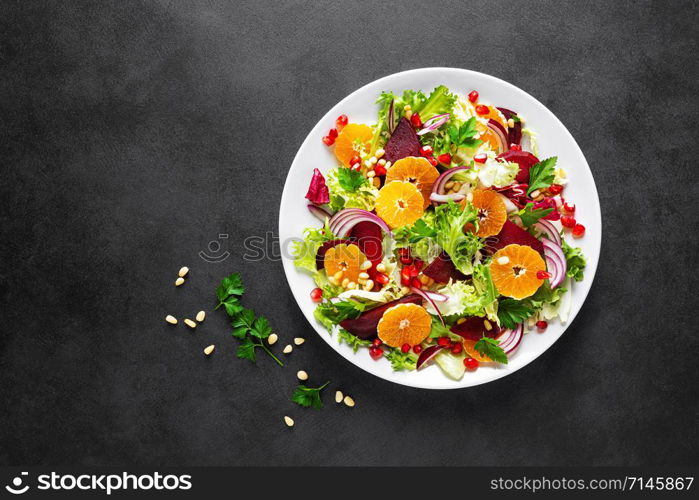 Christmas salad with boiled beet, red onion, tangerines, pomegranate, parsley, pine nuts and lettuce leaves