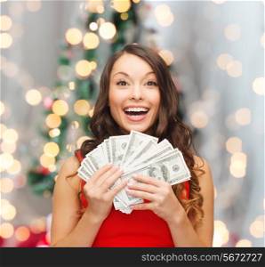christmas, sale, banking, winning and holidays concept - smiling woman in red dress with us dollar money over living room and christmas tree background