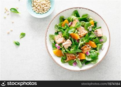 Christmas salmon orange salad with pine nuts, red onion and corn salad lettuce