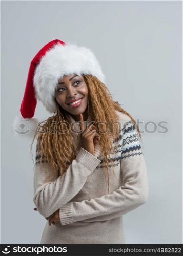 Christmas Santa hat woman portrait. Pensive happy girl on gray background