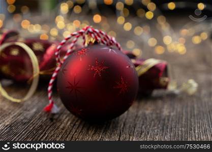 christmas scene with red and golden decorations and bokeh lights on natural wood background. red christmas with bokeh lights