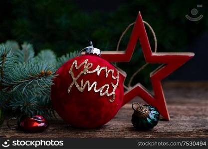 Christmas scene with red decorative ball and , merry Xmas greetings. Christmas flat lay scene with golden decorations