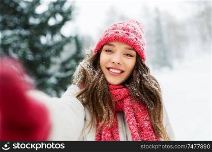 christmas, season and people concept - happy smiling woman taking selfie outdoors in winter park. smiling woman taking selfie outdoors in winter