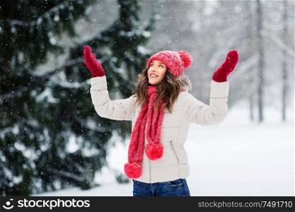 christmas, season and people concept - happy teenage girl or young woman in winter park. happy young woman in winter park