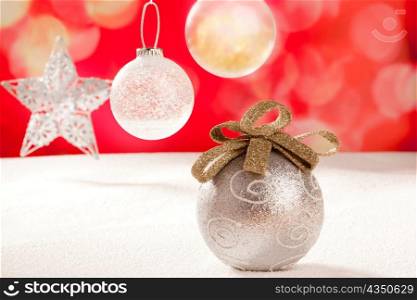 Christmas silver bauble and star on snow red background